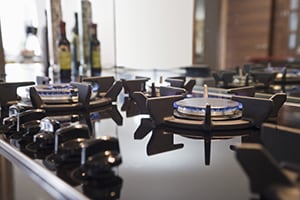Close-up view of stove. Picture of a stove integrated in a picture. It's a dark colored kitchen with a black tabletop.