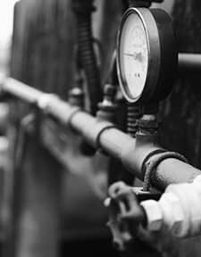 Black and white picture of a duct with a pressure gauge.