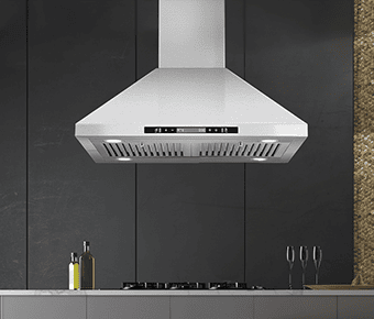 A kitchen shot of the Tieasy USGI1775B island range hood. It is brushed stainless steel in color and looks like the stereotypical chimney range hood. It has a black touch screen and four LED lights and two baffle filters. It has a dark backdrop.